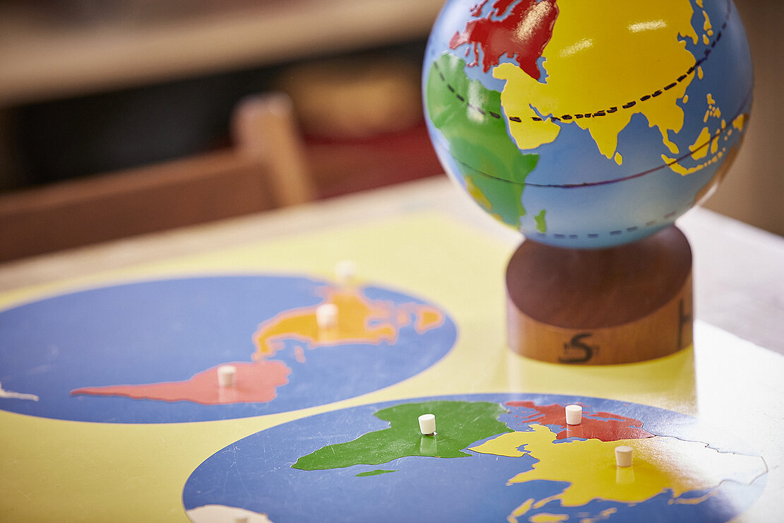 Weltkarte und Globus auf einem Tisch